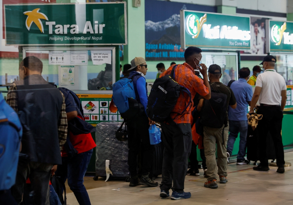 A group of mountaineers wait to board a flight as they head to search and rescue of a plane operated by Tara Air that went missing on Sunday with 22 people on board, while on its way to Jomsom, in Kathmandu, Nepal May 29, 2022. REUTERS/Navesh Chitrakar