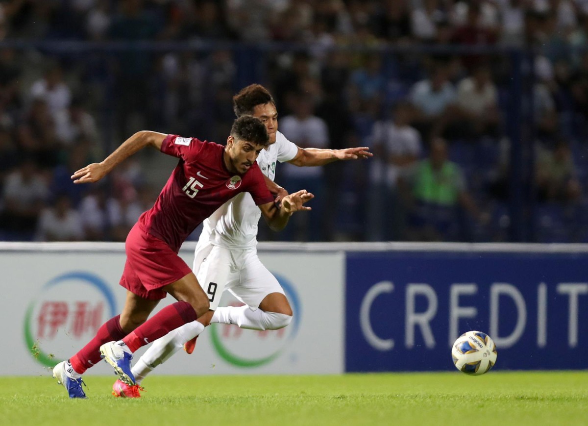 Qatar's Jassem Gaber vies for the ball with Uzbekistan's Ulugbek Khoshimov during yesterday's match.