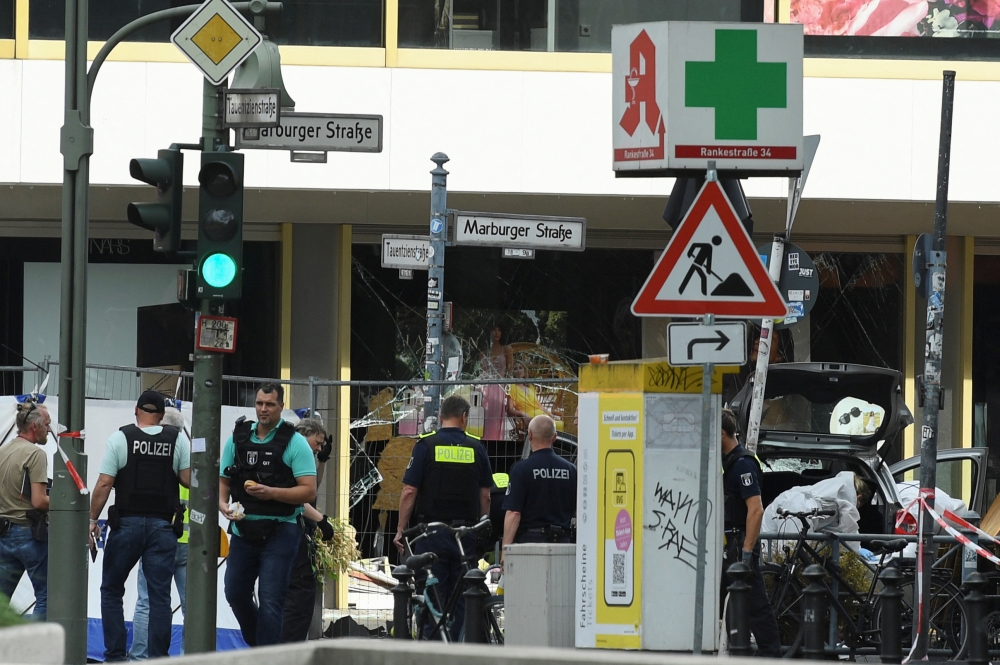 Forensic officers work on a car, at a crime scene where a car crashed into a group of people, near Breitscheidplatz in Berlin, Germany, June 8, 2022. REUTERS/Annegret Hilse