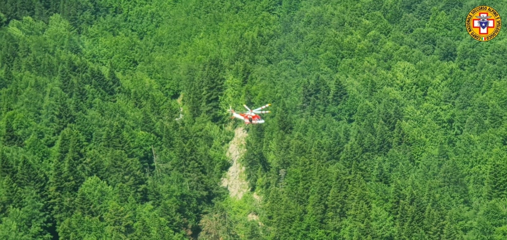 An Alpine Rescue helicopter flies over helicopter crash site near Pievepelago, Italy, June 11, 2022. 