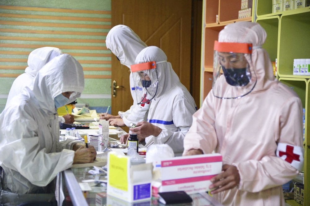 Members of the North Korean army supply medicines to residents at a pharmacy in Pyongyang, North Korea, in this photo released by Kyodo on May 18, 2022. Kyodo/via Reuters