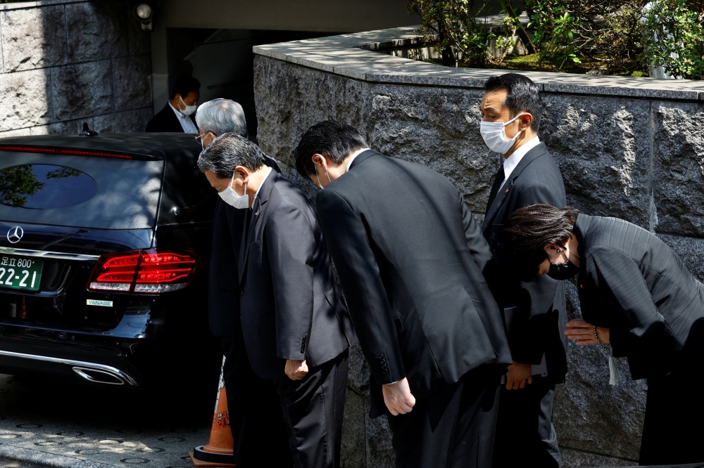 Japanese lawmaker Sanae Takaichi prays to the vehicle believed to be carrying the body of former Japanese Prime Minister Shinzo Abe, who was shot while campaigning for a parliamentary election, at his residence in Tokyo, Japan July 9, 2022. (REUTERS/ Kim Kyung-Hoon)