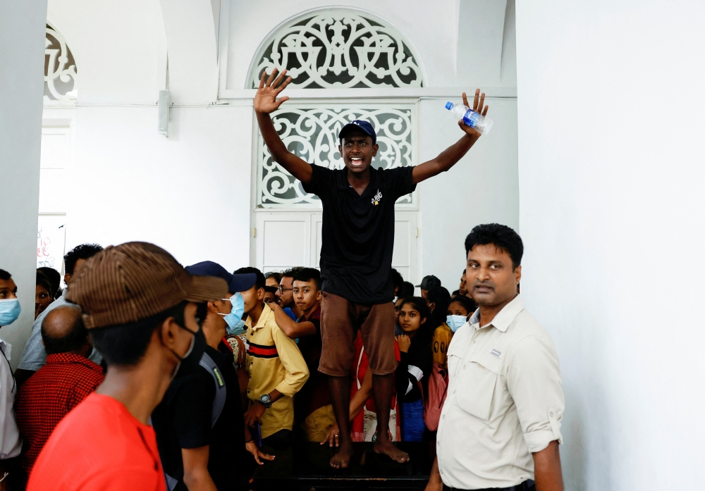 A demonstrator shouts to control the crowd inside President Gotabaya Rajapaksa's house, as demonstrators entered into the building after the president fled, amid the country's economic crisis, in Colombo, Sri Lanka, July 11, 2022. (REUTERS/Dinuka Liyanawatte)
