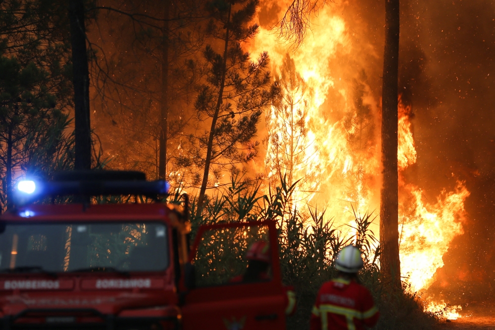 Firefighters watch a wildfire in Ourem, Santarem district, Portugal, July 12, 2022. (REUTERS/Rodrigo Antunes)

