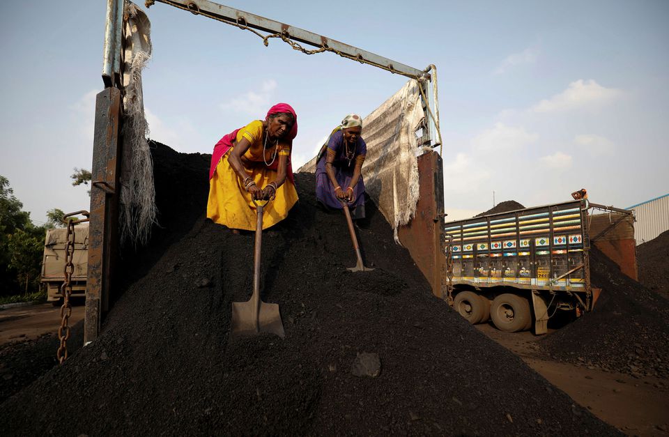Workers unload coal from a supply truck at a yard on the outskirts of Ahmedabad, India October 12, 2021. REUTERS/Amit Dave

