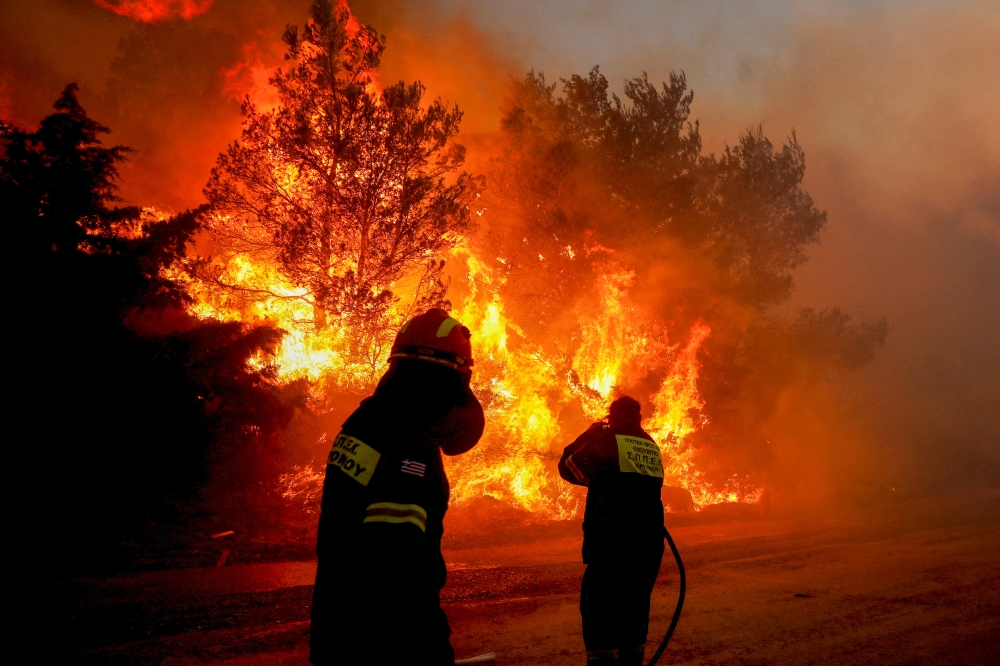 Firefighters try to extinguish a wildfire in Ntrafi, Athens, Greece, July 19, 2022. REUTERS/Costas Baltas
