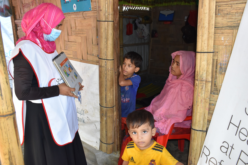 A volunteer talks to woman at a health centre.