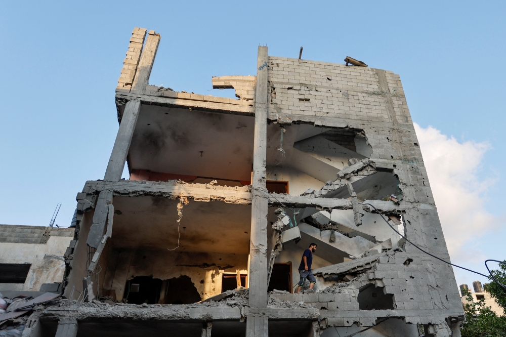 A Palestinian man walks through the ruins of a house at the scene where senior commander of Islamic Jihad militant group Khaled Mansour was killed in Israeli strikes, in Rafah in the southern Gaza Strip, August 7, 2022. REUTERS/Ibraheem Abu Mustafa