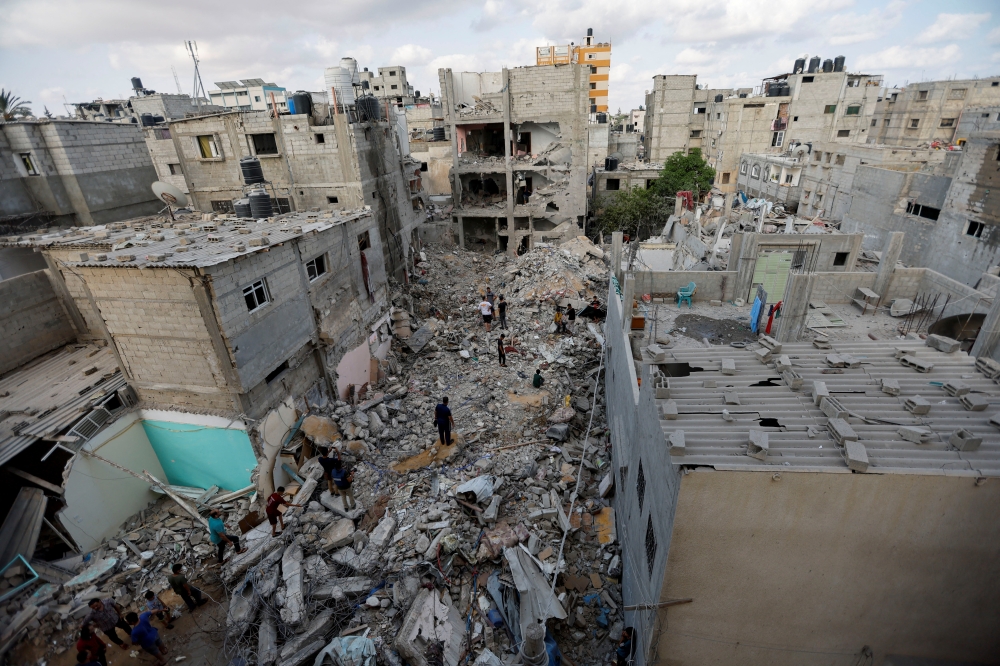 Palestinians gather on the rubble of houses in Rafah in the southern Gaza Strip on August 7, 2022. (REUTERS/Ibraheem Abu Mustafa)