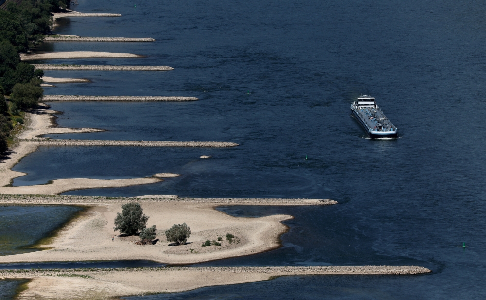 A transport vessel cruises past the partially dried riverbed of the Rhine river in Bingen, Germany, August 9, 2022. REUTERS/Wolfgang Rattay/File Photo