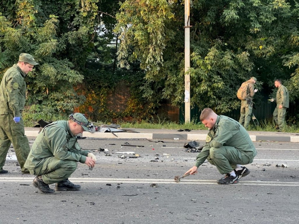 Investigators work at the site of a suspected car bomb attack that killed Darya Dugina in the Moscow region, Russia August 21, 2022. Investigative Committee of Russia/Handout via Reuters