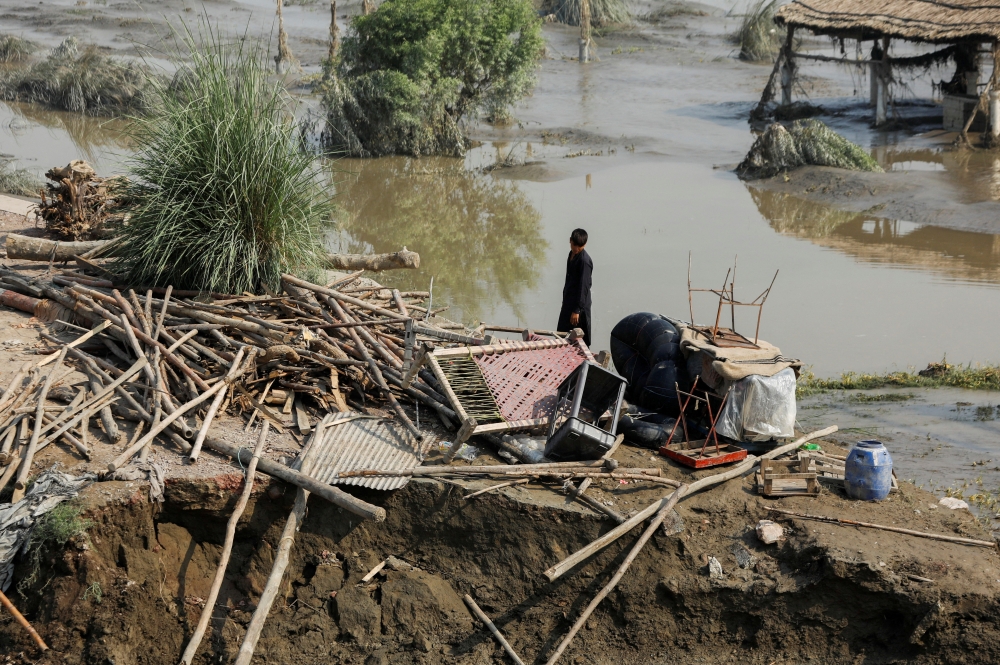 A flood victim stands amid the damages of his house, following rains and floods during the monsoon season, in Nowshera, Pakistan, on August 31, 2022. REUTERS/Fayaz Aziz/File Photo
