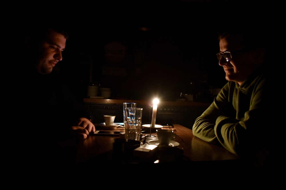 People have coffee at a bar during a power cut in Pristina, Kosovo, December 27, 2021. Picture taken December 27, 2021. REUTERS/Laura Hasani/File Photo