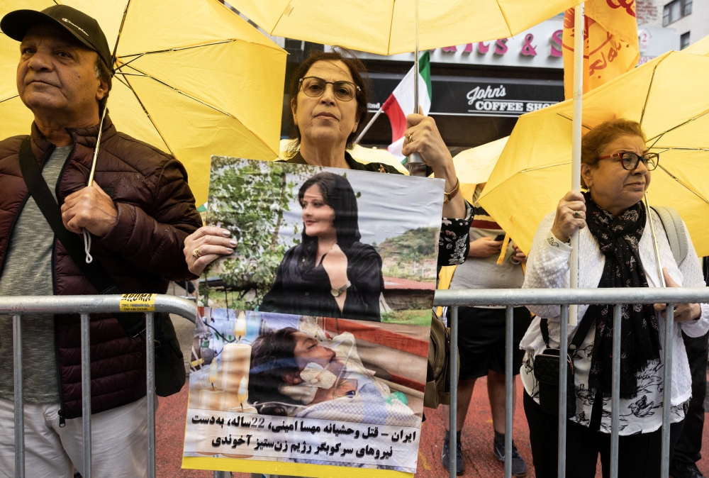 A demonstrator holds a picture of Mahsa Amini, who died in police custody in Iran, in New York City on September 22, 2022. REUTERS/Caitlin Ochs