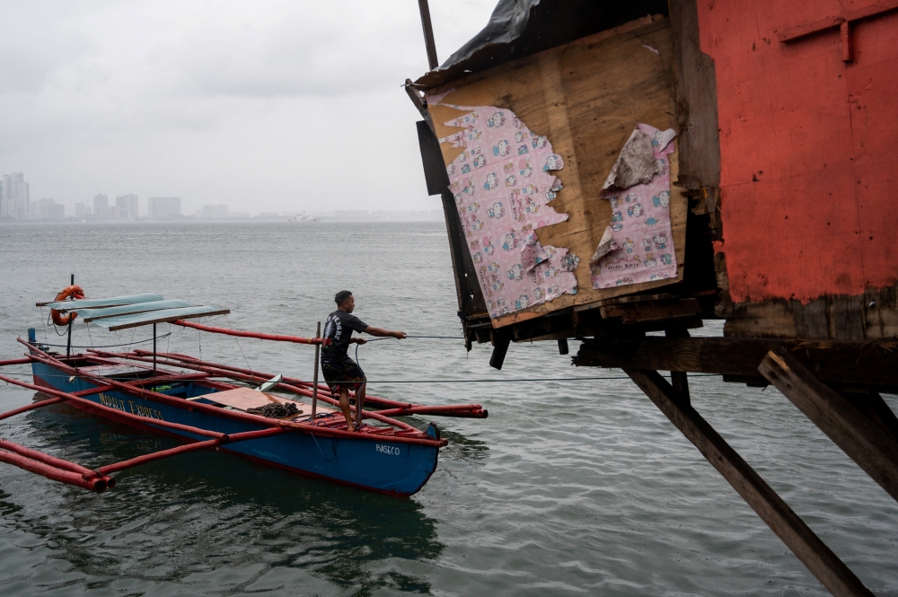 A man prepares to dock his boat, in preparation for Super Typhoon Noru, in Manila, Philippines, September 25, 2022. REUTERS/Lisa Marie David