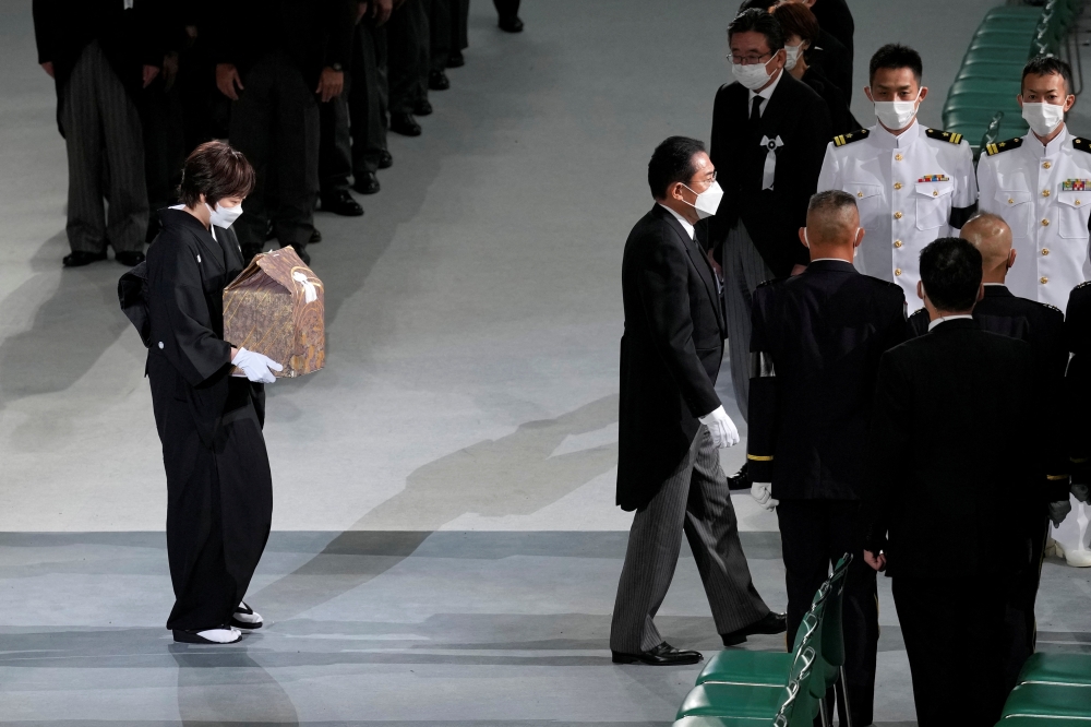 Akie Abe, wife of former Japanese Prime Minister Shinzo Abe, carries her husband's urn, as she leaves his state funeral at Nippon Budokan, in Tokyo, Japan, September 27, 2022. Eugene Hoshiko/Pool via Reuters 