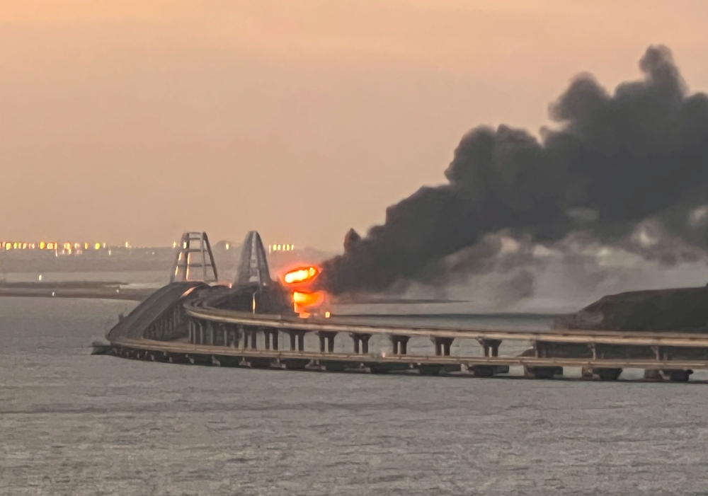 A view shows a fire on the Kerch bridge at sunrise in the Kerch Strait, Crimea, October 8, 2022. Reuters/Stringer