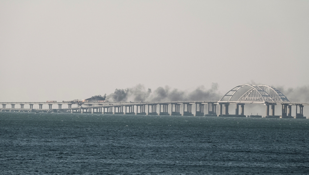 A view shows fuel tanks ablaze and damaged sections of the Kerch bridge in the Kerch Strait, Crimea, October 8, 2022. Reuters/Stringer
