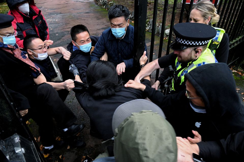 A man is pulled at the gate of the Chinese consulate after a demonstration against China's President Xi Jinping, in Manchester, Britain, on October 16, 2022. Matthew Leung/The Chaser News/Handout via REUTERS