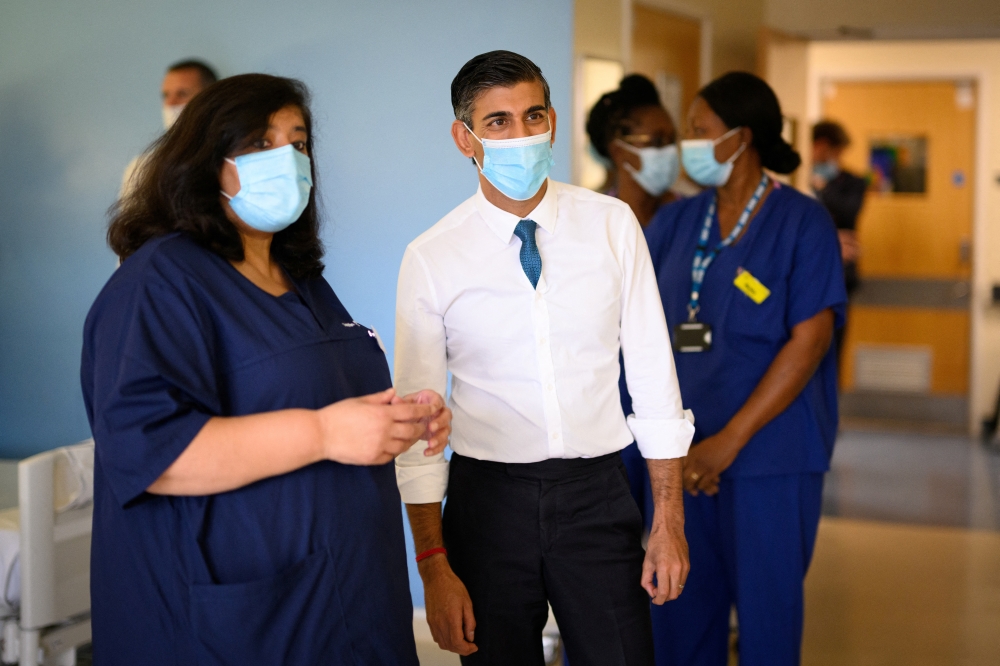 British Prime Minister Rishi Sunak speaks with members of staff as he visits Croydon University Hospital on October 28, 2022 in London, Britain. Leon Neal/Pool via REUTERS