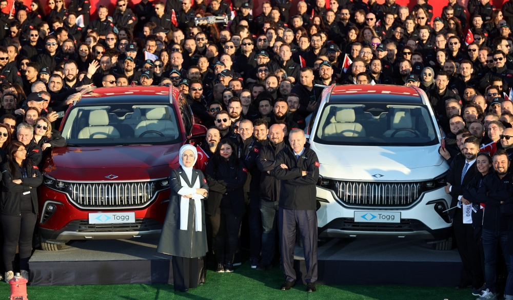 Turkish President Tayyip Erdogan and his wife Emine Erdogan pose with employees of TOGG before the opening ceremony of a factory to begin the mass production of its first domestic vehicle TOGG, in Gemlik, Turkiye, October 29, 2022. Murat Cetinmuhurdar