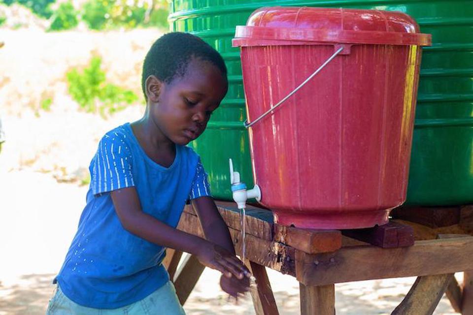 Photo: UNICEF Malawi 2022 (Elephant Media) - A 5-year-old boy washes his hands in Nedi Camp, Malawi.

