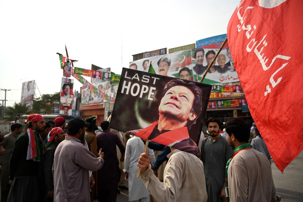 Supporters of former Pakistani prime minister Imran Khan, take part in a protest near the container truck a day after the assassination attempt on Khan, at the cordoned-off site of a gun attack in Wazirabad on November 4, 2022. (AFP/Aamir QURESHI)