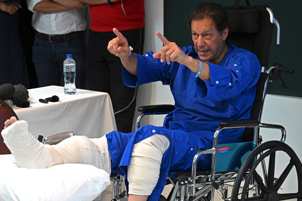 In this picture taken on November 4, 2022, Pakistan's former prime minister Imran Khan addresses the media representatives at a hospital in Lahore. (AFP/Arif Ali)