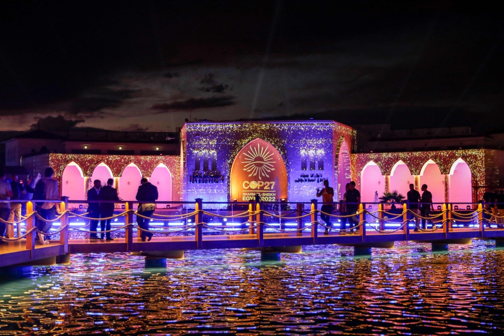 People walk outside the Sinai Diorama for Biodiversity at the green zone of the Sharm el-Sheikh International Convention Centre during the COP27 climate conference on November 14, 2022. (AFP/Mohammed Abed)