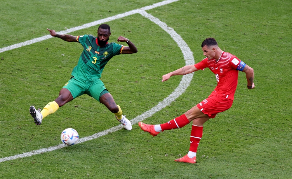 Switzerland's Granit Xhaka in action with Cameroon's Nicolas Nkoulou during the Qatar 2022 World Cup Group G football match between Switzerland and Cameroon at the Al-Janoub Stadium in Al-Wakrah, south of Doha on November 24, 2022. (Photo by Glyn KIRK / AFP)