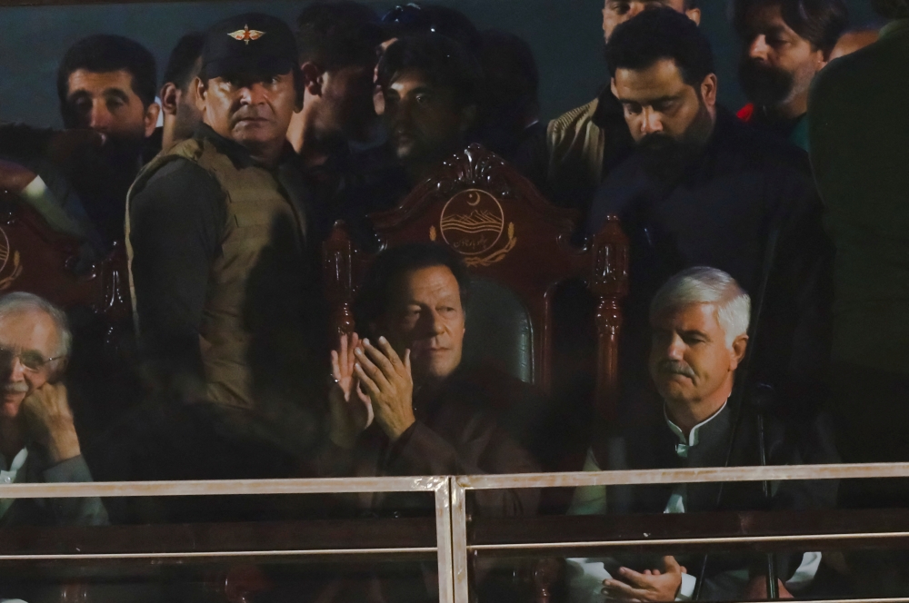 Pakistan's former Prime Minister, Imran Khan, gestures from behind a bullet-proof glass window, in his first public appearance since him being wounded in a gun attack earlier this month, during so-called 'a true freedom march' to pressure the government to announce new elections, in Rawalpindi, Pakistan, on November 26, 2022. REUTERS/Akhtar Soomro
 