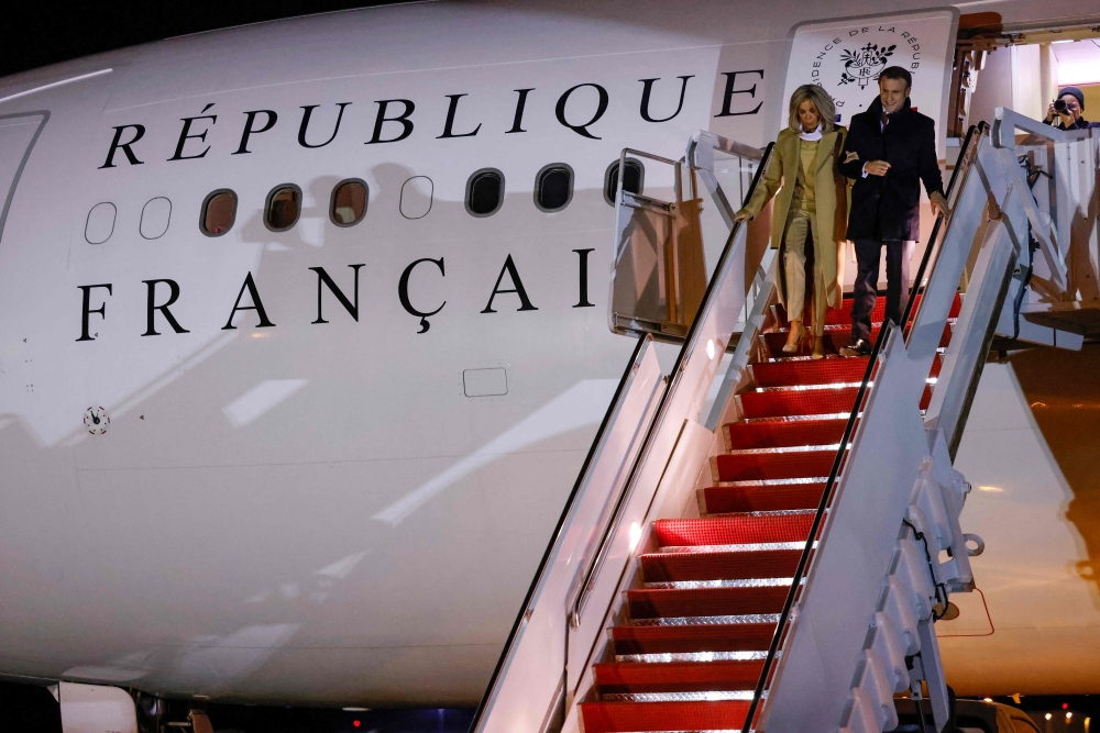 French President Emmanuel Macron (R) and his wife Brigitte Macron disembark from their plane upon arrival at Joint Base Andrews in Maryland on November 29, 2022. (Photo by Ludovic MARIN / AFP)
 