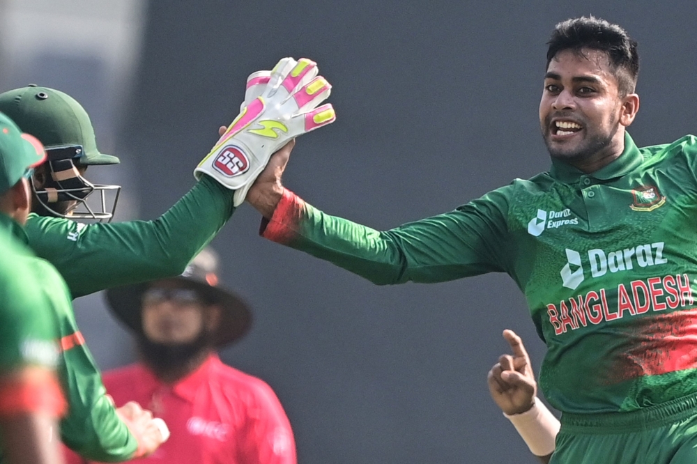 Bangladesh's Mehidy Hasan Miraz (R) celebrates with teammates after the dismissal of Indian's Shikhar Dhawan (unseen) on December 4, 2022. (Photo by Munir uz Zaman / AFP)