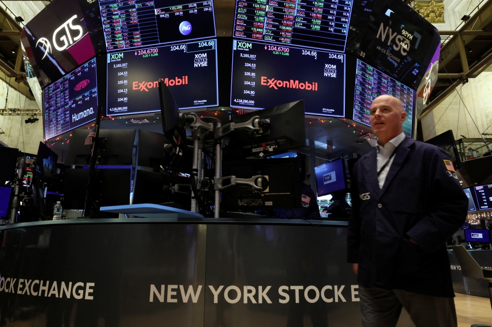 Screens display the trading information for ExxonMobil on the floor of the New York Stock Exchange (NYSE) in New York City, US, on December 9, 2022. REUTERS/Brendan McDermid
