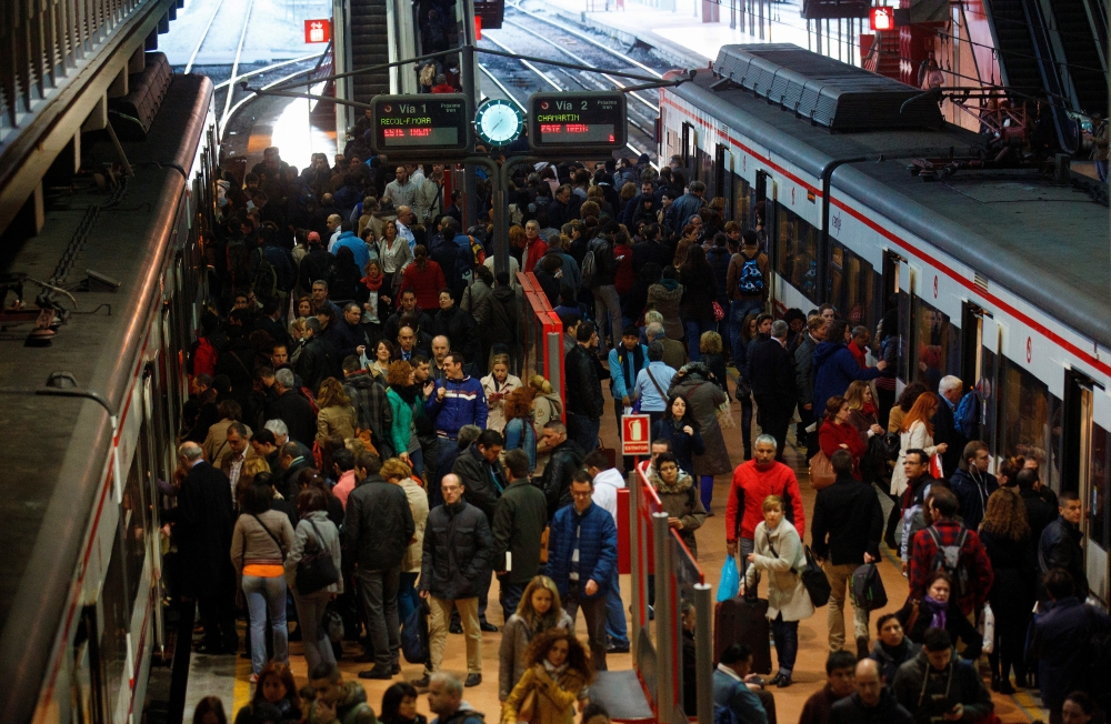 Commuters get on and off their trains at Madrid's Atocha station March 11, 2014. REUTERS/Andrea Comas/File Photo