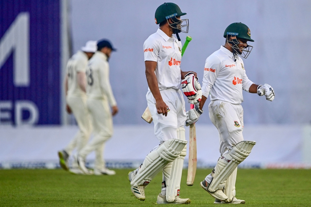 India's Nazmul Hasan Santo (L) and Zakir Hasan (R) walk off the field after the second day of the second cricket Test match between Bangladesh and India on December 23, 2022. (Photo by Munir uz Zaman / AFP)