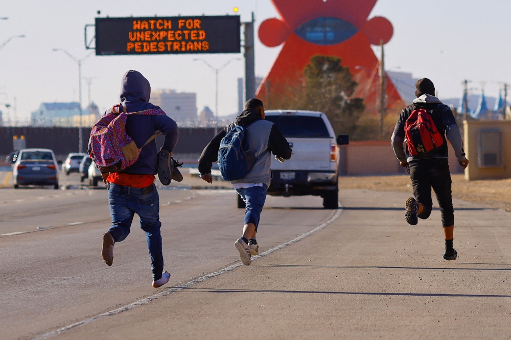 Migrants run to hide from the US Border Patrol and Texas State Troopers after crossing into the United States from Mexico, in El Paso, Texas, US, on December 23, 2022. REUTERS/Jose Luis Gonzalez