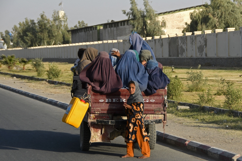 Some Afghan women travel in a vehicle along the road in Kandahar on December 25, 2022. (Photo by Naveed Tanveer / AFP)
