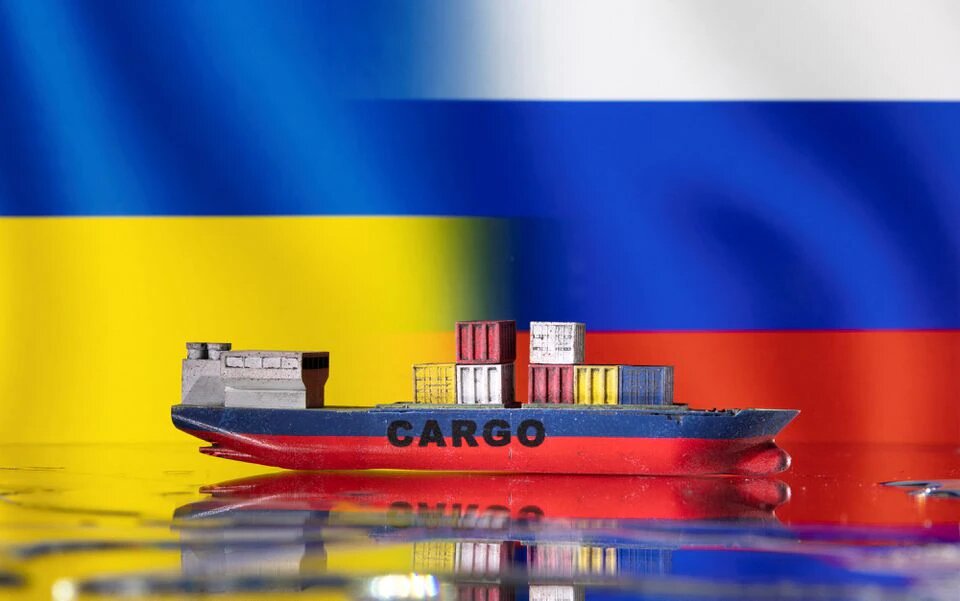 A cargo ship boat model is pictured in front of Ukraine's and Russian's flags in this illustration taken on March 3, 2022. File Photo / Reuters