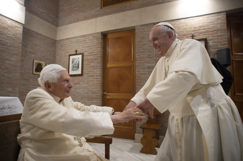 This photo taken and handout on November 28, 2020 by The Vatican Media shows Pope Francis (R) greeting Pope Emeritus Benedict XVI following a consistory to create 13 new cardinals, on November 28, 2020 in The Vatican. (Photo by Vatican Media / AFP)