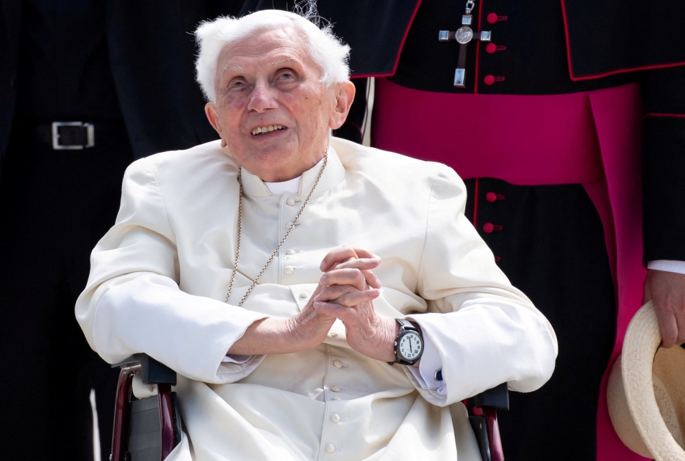 File photo: Pope Emeritus Benedict XVI gestures at the Munich Airport before his departure to Rome, June 22, 2020. Sven Hoppe/Pool via Reuters/File Photo