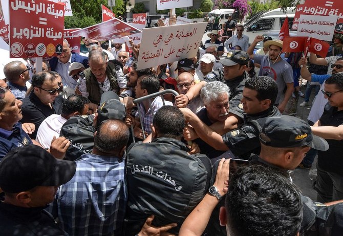 Tunisian demonstrators blocked by police during a rally against their president, in the capital Tunis, on June 4, 2022. (AFP)

