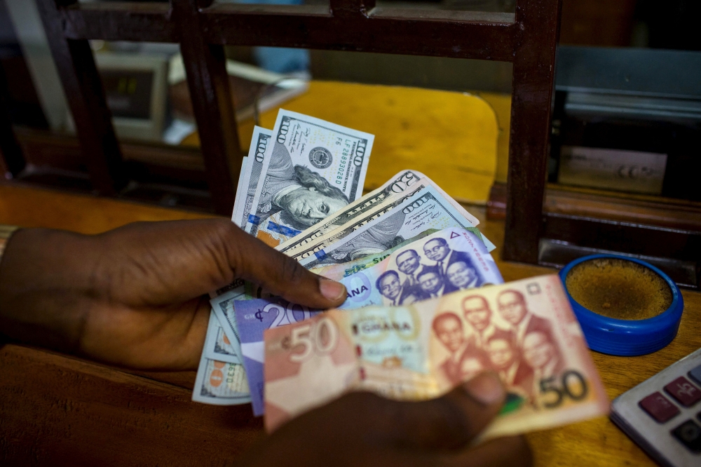 A man trades US dollars for Ghanaian cedis at a currency exchange office in Accra, Ghana, June 15, 2015. Picture taken June 15. File Photo / Reuters