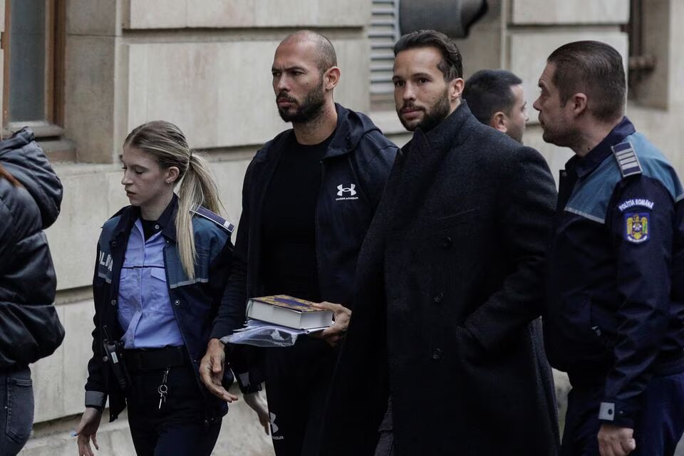 Andrew Tate and his brother Tristan are escorted by police officers outside the headquarters of the Bucharest Court of Appeal, in Bucharest, Romania, on January 10, 2023. Inquam Photos/Octav Ganea via REUTERS
