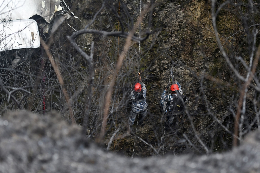 Rescuers inspect the wreckage at the site of a Yeti Airlines plane crash in Pokhara on January 16, 2023. (Photo by PRAKASH MATHEMA / AFP)