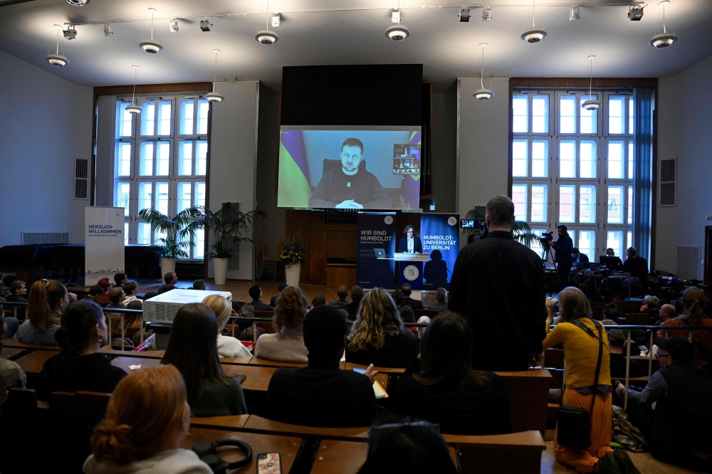 Ukrainian President Volodymyr Zelensky is displayed on a screen as he addresses students per video link at the Humboldt university in Berlin on January 17, 2023. (Photo by Tobias Schwarz / AFP)

