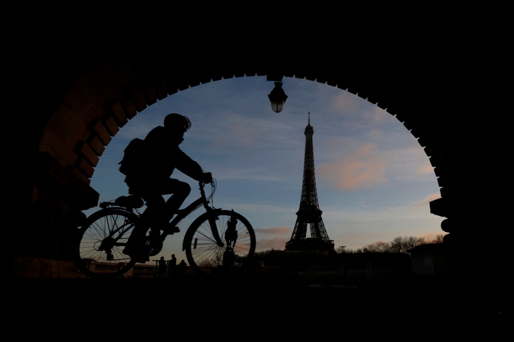 A man rides a bicycle along a bike path on the Pont de Bir-Hakeim bridge near the Eiffel Tower in Paris during a nationwide day of strike and protests against French government's pension reform plan in France, January 19, 2023. (REUTERS/Gonzalo Fuentes)