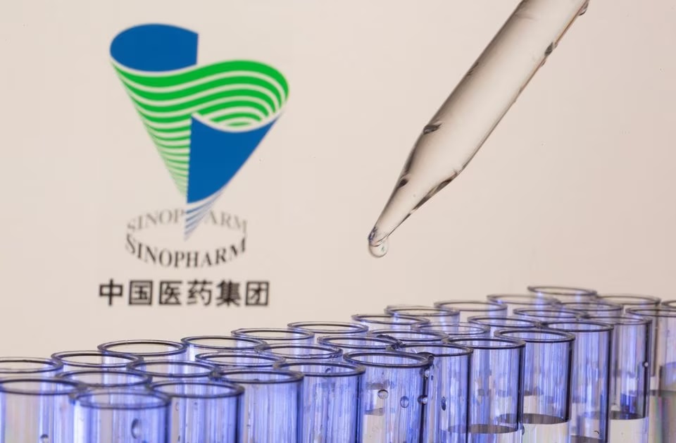 Test tubes are seen in front of a displayed Sinopharm logo in this illustration taken, May 21, 2021. REUTERS/Dado Ruvic/Illustration
