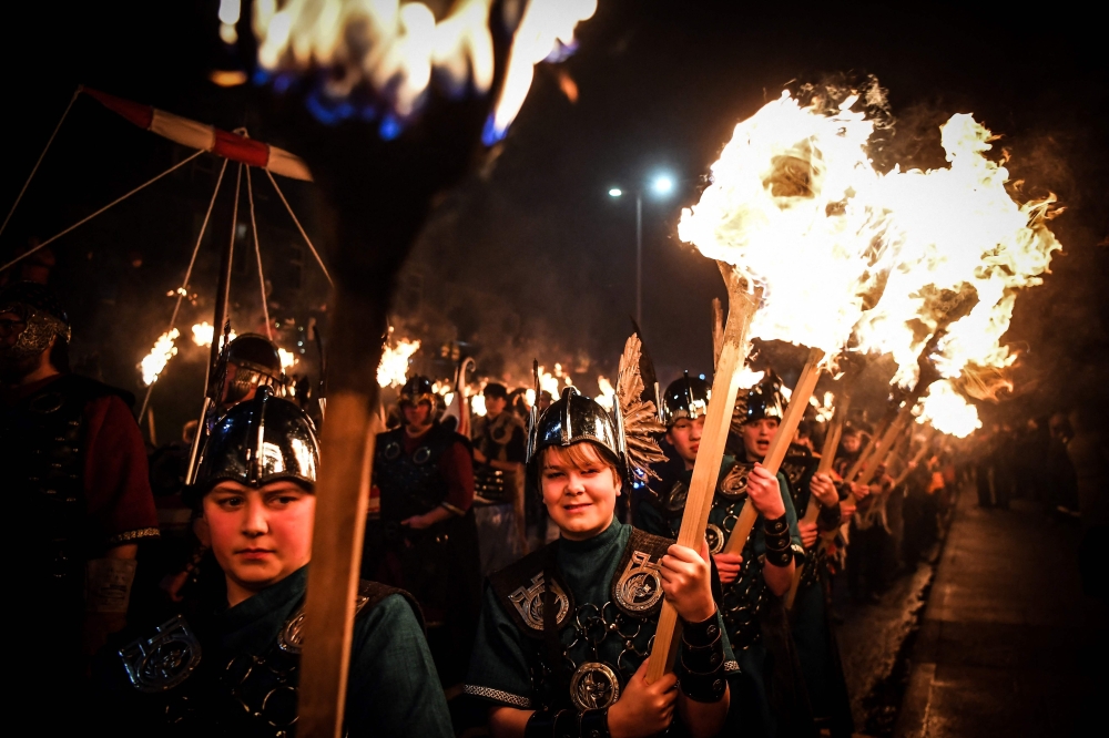 Young participants parade through the streets in Lerwick, Shetland Islands on January 31, 2023 as they take part in the Junior Up Helly Aa fire festival. (Photo by Andy Buchanan / AFP)
