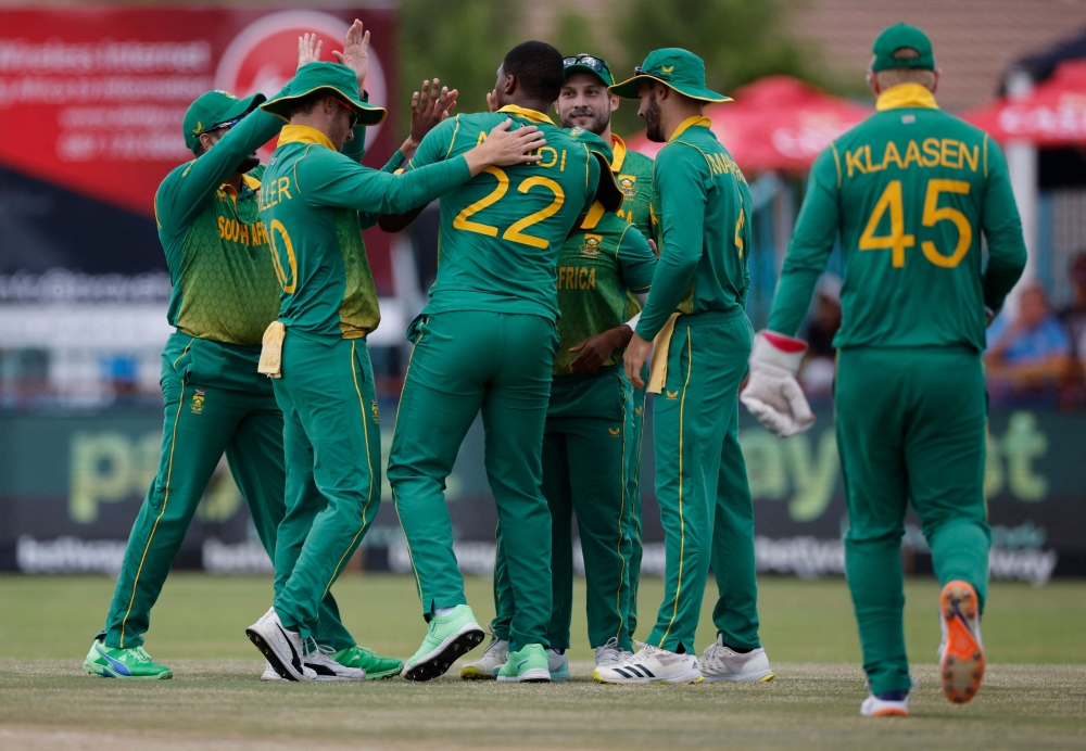 South Africa's Lungi Ngidi (C) celebrates with teammates after the dismissal of unseen England's Jason Roy during the third one day international (ODI) cricket match between South Africa and England at Mangaung Oval in Kimberley on February 1, 2023. (Photo by Marco Longari / AFP)